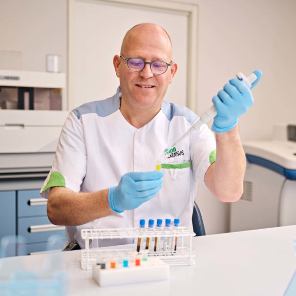 Medewerker in het laboratorium doet vloeistof in een reageerbuisje. In het klinisch laboratorium van het Anna Ziekenhuis verzamelen en onderzoeken we bloed en andere lichaamsmaterialen, zoals urine, ontlasting en sperma.
