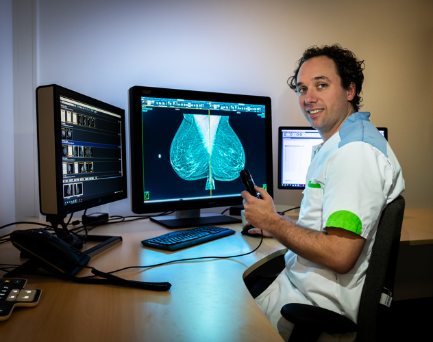 Foto van Rob van Bommel, radioloog bij het Anna Ziekenhuis Radioloog Rob controleert de mammografie van een patiënt