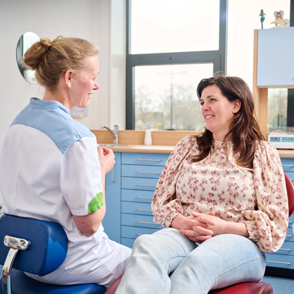 Patiënt ligt in stoel bij tandarts terwijl ze met elkaar praten Specifieke expertise centrum voor bijzondere tandheelkunde