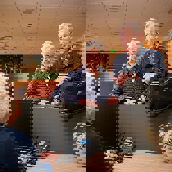 Echtpaar staat met weekendtas bij balie en praat met receptioniste Bureau opname helpt je voor te bereiden op een operatie