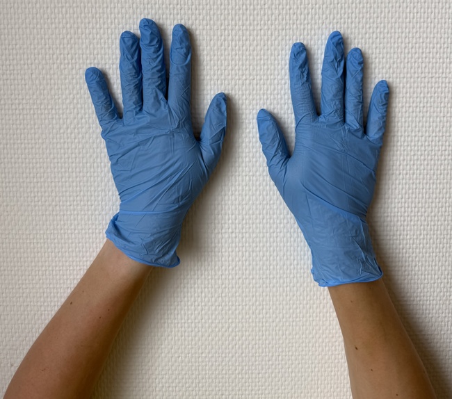 Twee handen in blauwe handschoenen