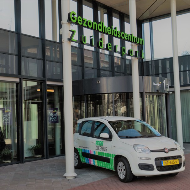 Voorzijde gebouw bloedafnamelocatie Gezondheidscentrum Zuiderpark in Eindhoven. Met geparkeerde auto met logo Anna Ziekenhuis. Bij het Anna Ziekenhuis kun je op meerdere locaties in de regio bloed laten afnemen en lichaamsmateriaal zoals urine en ontlasting inleveren.