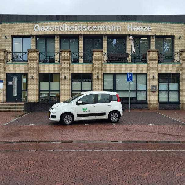 Voorzijde gebouw bloedafnamelocatie Huisartsenpraktijk Stalpers in Heeze. Met geparkeerde auto met logo Anna Ziekenhuis. Bij het Anna Ziekenhuis kun je op meerdere locaties in de regio bloed laten afnemen en lichaamsmateriaal zoals urine en ontlasting inleveren.